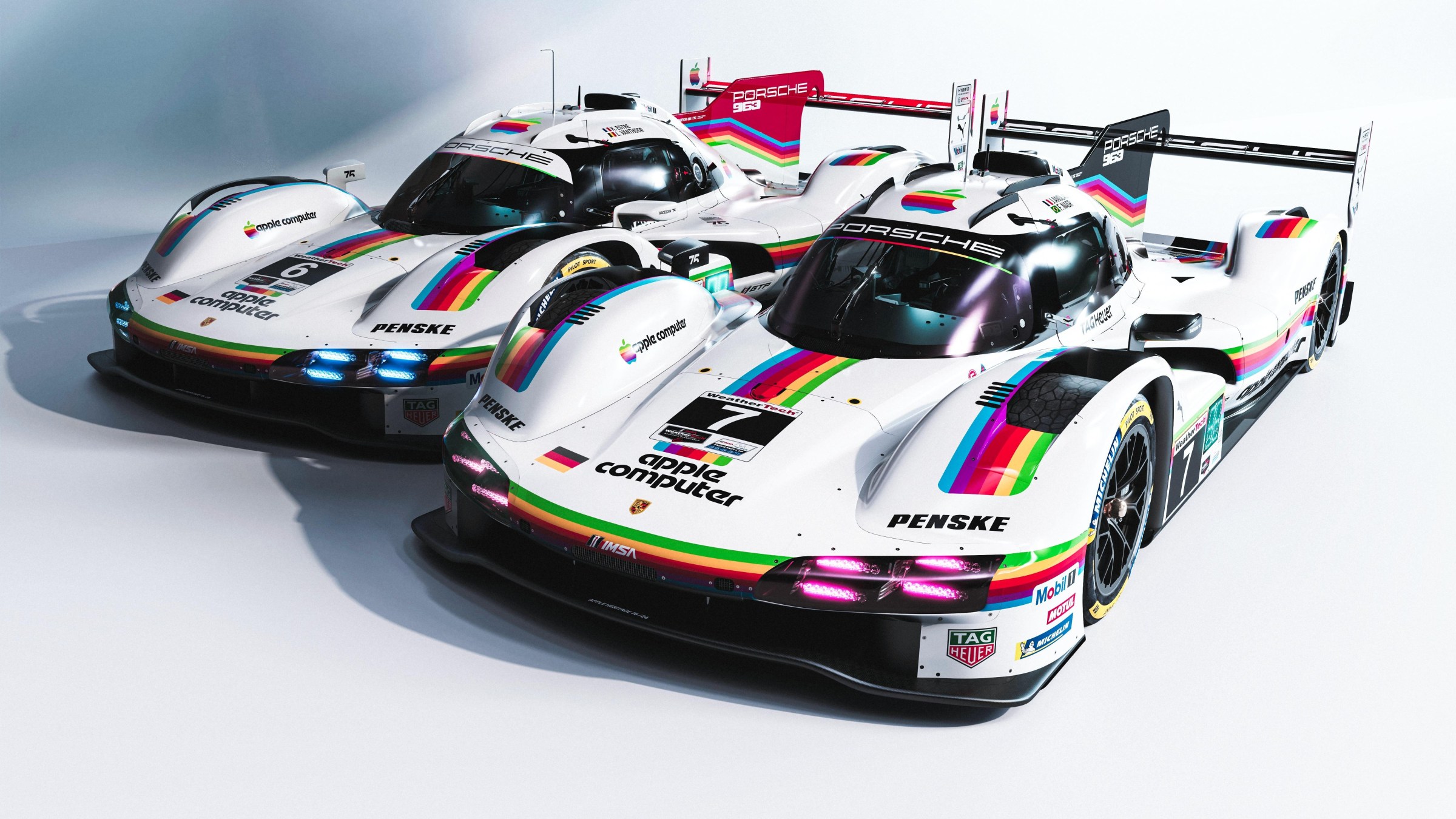 Two Porsche 963 LMDh cars in Apple livery